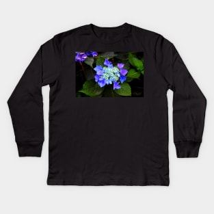 Close-up of a hydrangea with blue buds and flowers as well as green foliage Kids Long Sleeve T-Shirt